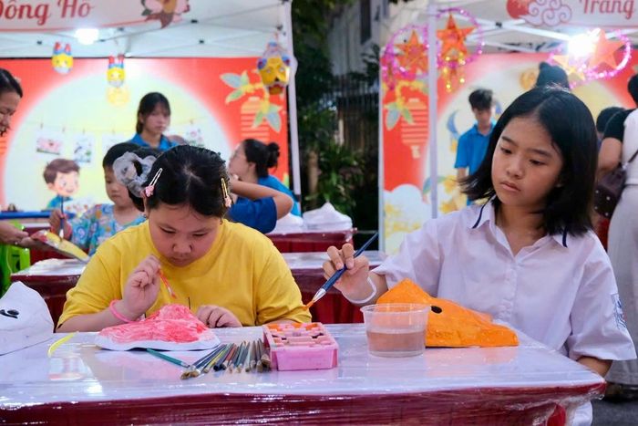 Các em thiếu nhi trải nghiệm vẽ mặt nạ giấy bồi tại Đêm hội trăng rằm. Ảnh: H.Duy