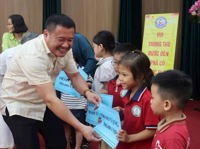Ông Nguyễn Văn Triệu, Giám đốc Trung tâm Công tác xã hội và Quỹ Bảo trợ trẻ em Hà Nội trao kinh phí và quà cho các em. Ảnh: Phạm Ban
