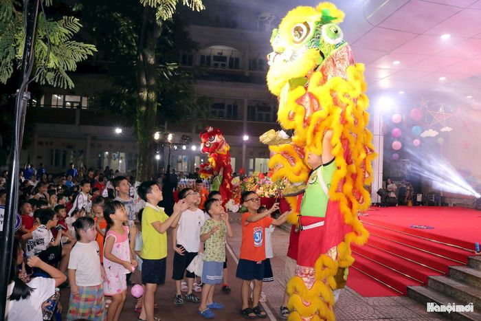 Trẻ em phường Nghĩa Đô vui vẻ giao lưu với đội múa lân. Ảnh: MT