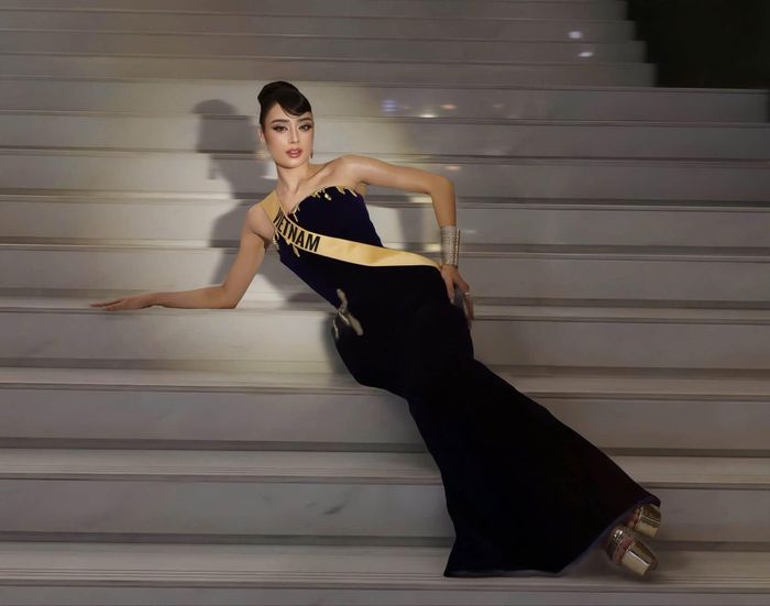 Nhưng điểm nhấn nhất trong ngày này của cô là chiếc đầm nhung xanh họa tiết vàng nổi bật. Người đẹp kết hợp trang phục cùng trang sức tinh tế và kiểu tóc búi gọn gàng, tạo tổng thể thanh lịch nhưng vẫn giữ được vẻ sang trọng. Cách lựa chọn trang phục giúp đại diện Việt Nam nổi bật trong những khung hình được chia sẻ trên mạng xã hội. 
