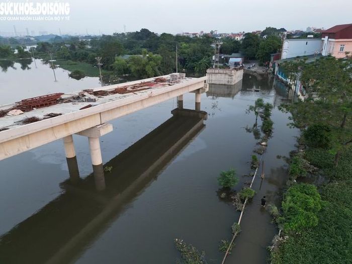Ngay bên cạnh cầu tạm, dự án cầu Tân Phú có chiều dài khoảng 500m (gồm đường dẫn và cầu) hiện vẫn đang được triển khai. Công trình khởi công năm 2024, dự kiến hoàn thành cuối 2025, song do gặp một số khó khăn, vướng mắc nên chậm tiến độ.