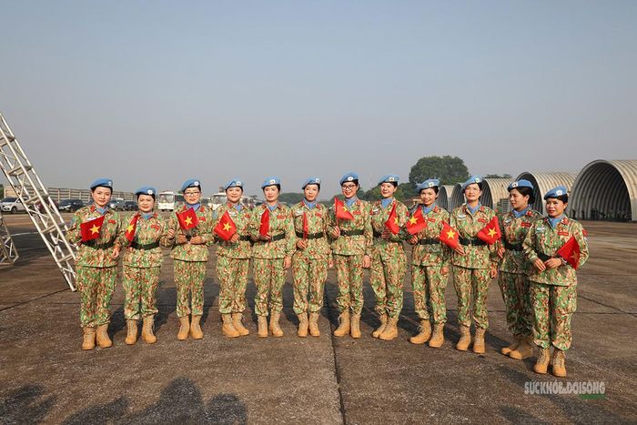 Các nữ quân nhân mũ nồi xanh vẫy chào đồng đội trước giờ xuất quân. Ảnh: Văn Giang