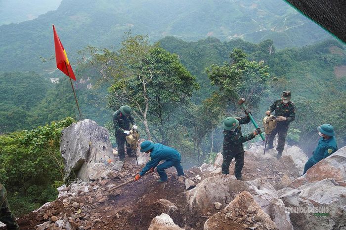 Lực lượng chức năng mở lối vào hang, nơi nghi có nhiều hài cốt liệt sĩ. Ảnh: Tuấn Anh