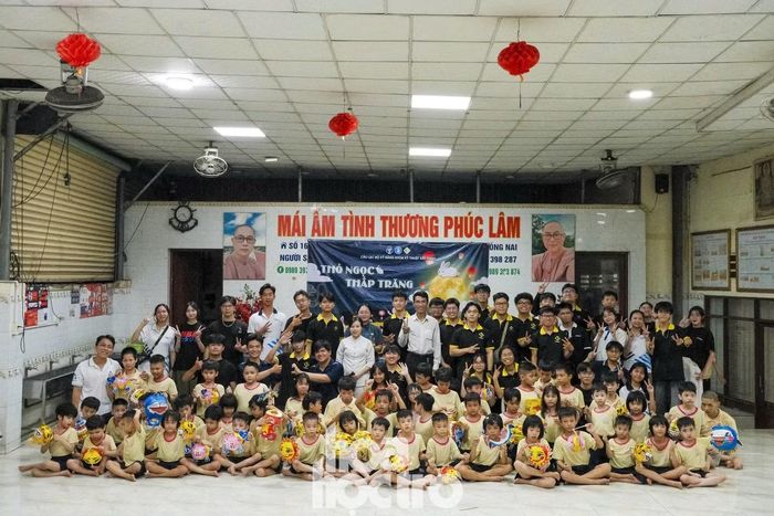 Ban tổ chức cùng các bé tại mái ấm chụp ảnh lưu niệm.
