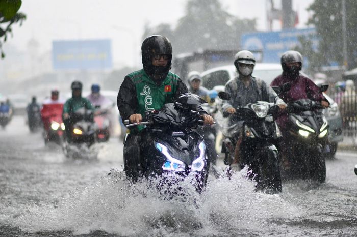 Cơ quan khí tượng cảnh báo mưa lớn trong thời gian ngắn có thể gây ngập tại các khu vực trũng thấp, đô thị, ven sông và kênh rạch. Trong cơn dông, người dân cần đề phòng lốc, sét và gió giật mạnh. Trong ảnh, người dân di chuyển qua vùng nước ngập tại đường Nguyễn Thị Minh Khai, giao Hoàng Sa, trong cơn mưa chiều 23/9.