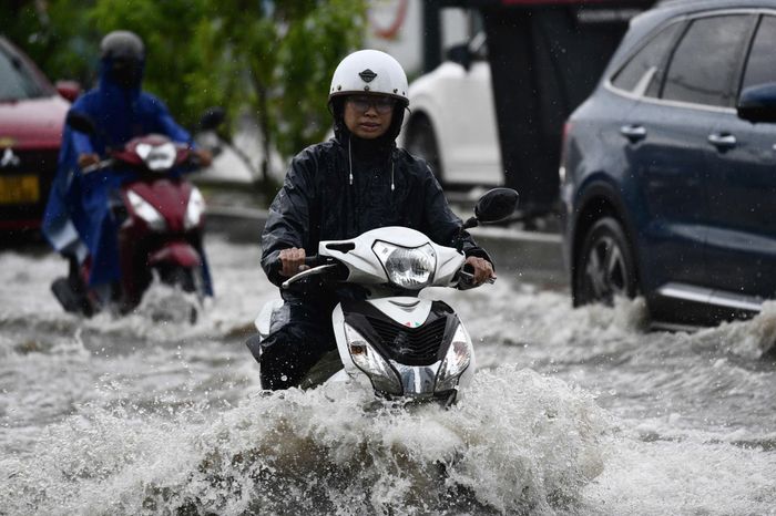Người dân chật vật chạy xe qua đoạn đường ngập nước gần cầu Ba Son.