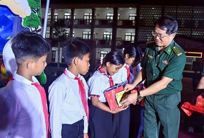 Đại tá Đặng Ngọc Hiệu trao quà cho các học sinh vượt khó. Ảnh: V.T
