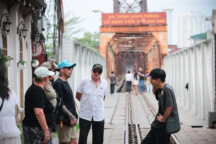 Hướng dẫn viên giới thiệu về cầu Long Biên - công trình mang dấu ấn lịch sử của Hà Nội dịp nghỉ Lễ Giỗ tổ. Ảnh: Phạm Tuấn Anh - TTXVN
