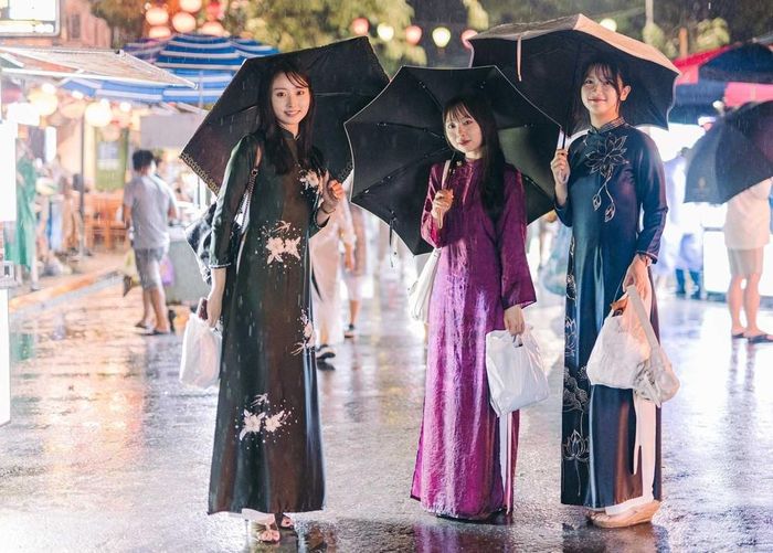 Ba nữ du khách Nhật Bản mặc áo dài dạo phố Hội An trong mưa