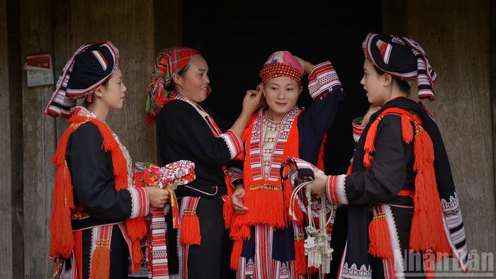Cô dâu thực hiện từng bước quấn khăn. (Ảnh: VŨ LINH)