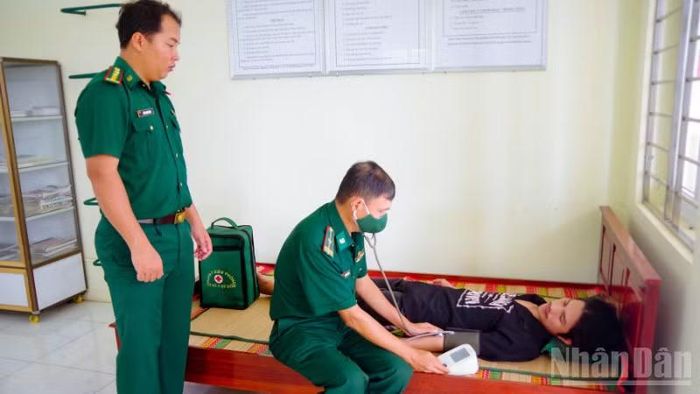 Cán bộ Quân y đồn Biên phòng Trung Bình thăm khám sức khỏe cho các ngư dân. (Ảnh: VĂN LONG)