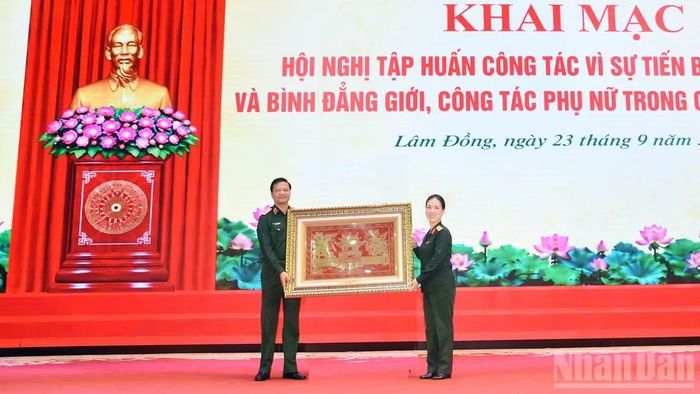 Đại diện Ban Vì sự tiến bộ của phụ nữ Bộ Quốc phòng tặng quà Học viện Lục quân. (Ảnh: BẢO VĂN)