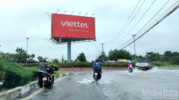 Phương tiện lưu thông bị chết máy phải dẫn bộ qua khu vực vòng xoay cửa ngõ đoạn thuộc phường Tân Thành, tỉnh Cà Mau do mặt đường bị ngập nước.