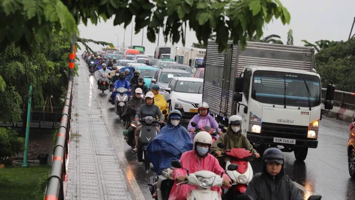 Dòng phương tiện nối đuôi qua cầu Bình Triệu trong cơn mưa lớn kéo dài từ trưa đến chiều 23/9 (Ảnh: VÕ LÊ)