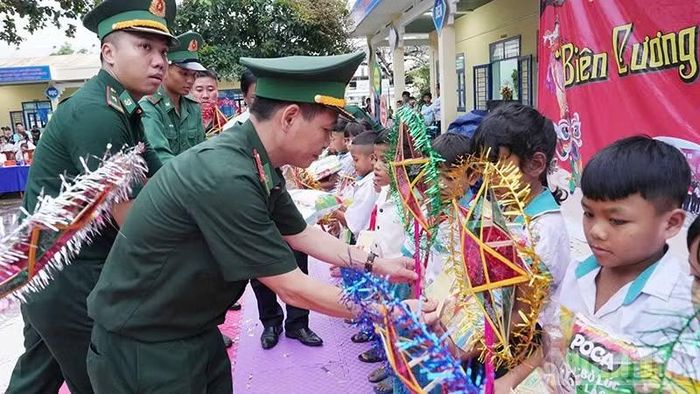 Các cán bộ chiến sĩ Biên phòng trao quà cho các em thiếu nhi trên địa bàn. (Ảnh: BP)