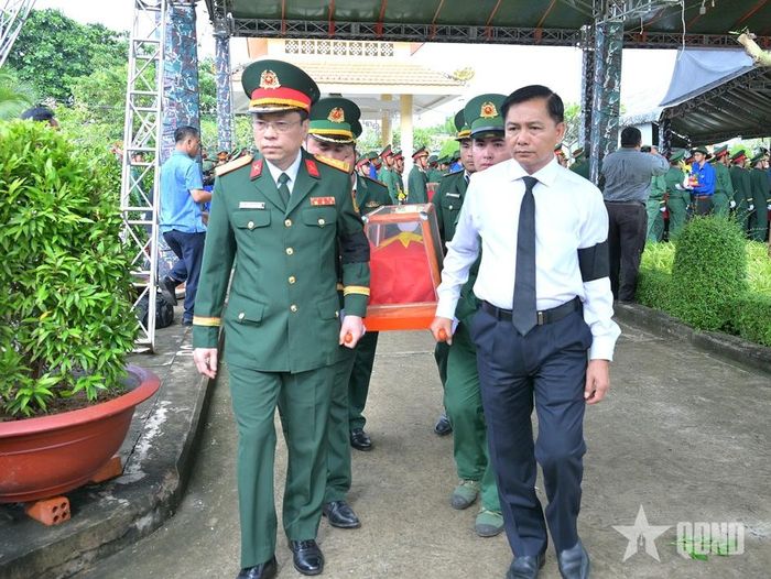 Các đại biểu di chuyển hài cốt liệt sĩ về nơi an táng.