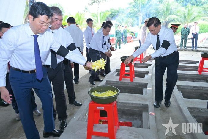Các đại biểu thực hiện nghi lễ an táng hài cốt liệt sĩ.