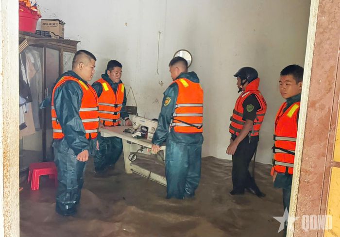 Lực lượng dân quân hỗ trợ người dân di chuyển tài sản.