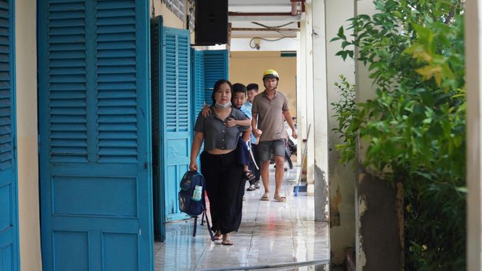Phụ huynh cõng con vào lớp do sân trường ngập sâu sau cơn mưa lớn
