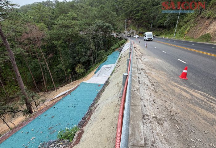  Một đoạn taluy âm vừa bị sạt lở được cơ quan chức năng phủ bạt tạm thời. Ảnh: ĐOÀN KIÊN 