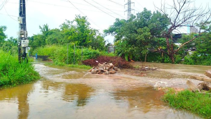 Nước từ kênh thoát lũ tràn lên đường khu dân cư cầu Suối Cát (xã Hàm Liêm, tỉnh Lâm Đồng). Ảnh: TIẾN THẮNG