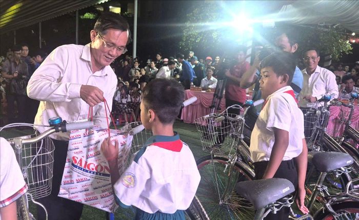 Phó Tổng Biên tập Báo SGGP Nguyễn Đức Hiển trao quà tặng các em học sinh