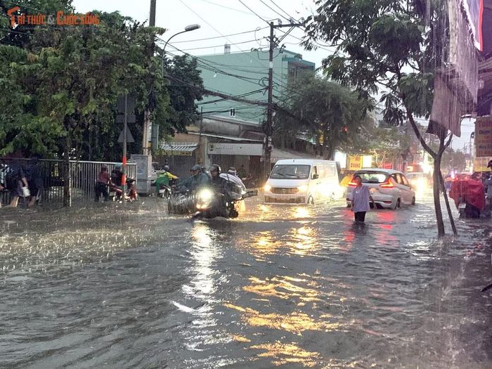 Sau cơn mưa 30 phút, đường Mã Lò (quận Bình Tân cũ) thuộc phường Bình Trị Đông mênh mông nước. Mưa ngập đường vào giờ tan tầm khiến nhiều học sinh không dám về nhà.