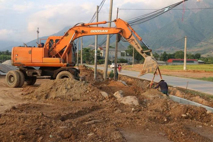 Các công nhân đang huy động máy móc làm cống rãnh.