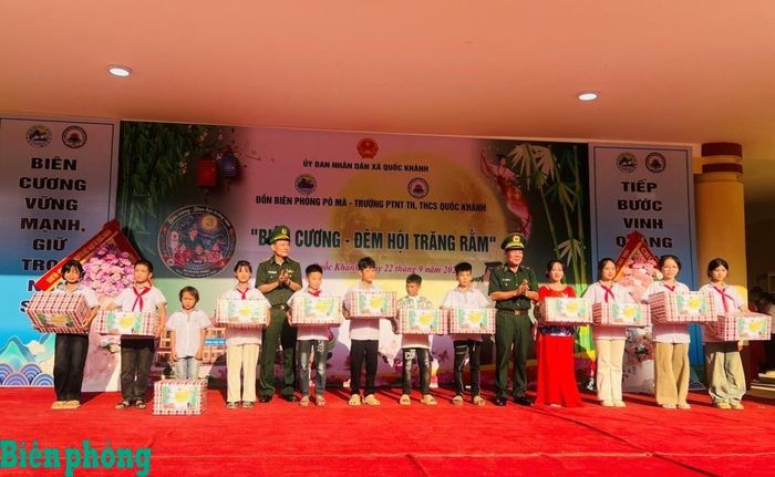 Thiếu tướng Văn Ngọc Quế và Đại tá Nguyễn Xuân Thanh tặng quà cho các em học sinh thuộc chương trình “Nâng bước em tới trường” và mô hình “Con nuôi đồn Biên phòng”. Ảnh: Duy Khiêm