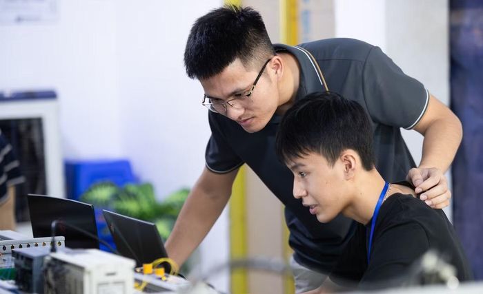 Anh Lê Quốc Bảo (người đeo kính), người sáng lập MunTech Service Lab hướng dẫn công việc cho sinh viên thực tập. Ảnh: Lê Vượng