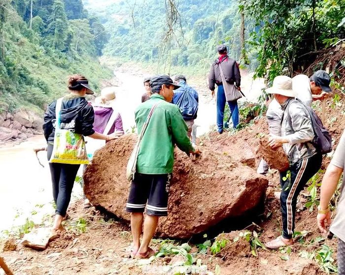 Với những tảng đá quá lớn, không thể di chuyển bằng sức người, bà con phải chờ xe cẩu hỗ trợ. Dù vất vả, mọi người vẫn cố gắng khắc phục từng vị trí để tạo lối đi thuận lợi hơn.