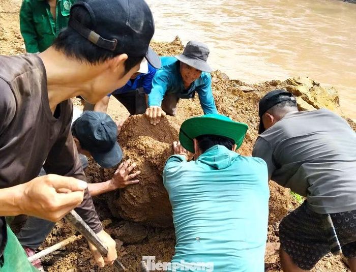 Có những tảng đá lớn nằm chắn ngang lối đi. Người dân phải dùng những thanh gỗ làm đòn bẩy để đẩy những khối đá ra khỏi mặt đường.