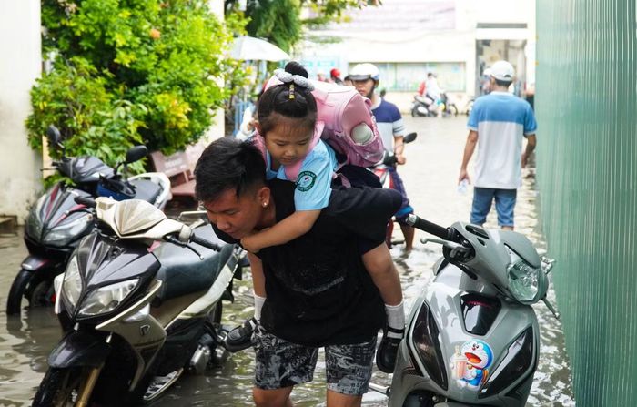Chạy xe máy vào hành lang lớp học, người cha cẩn thận cõng con gái trên lưng
