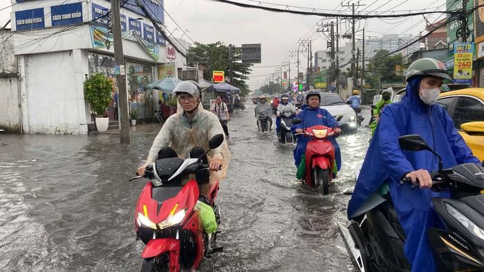 Người dân di chuyển trong cơn mưa lớn tại TPHCM chiều 22/9