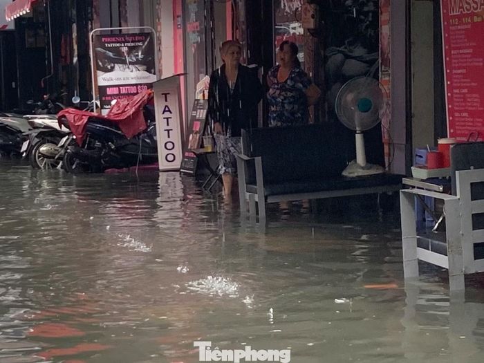 Một số hộ kinh doanh phải kê cao vật dụng, hàng hóa trước cửa để hạn chế nước tràn vào.