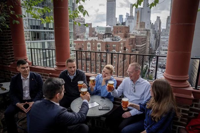 Thủ tướng Đan Mạch Mette Frederiksen, Thủ hiến Greenland Jens-Frederik Nielsen và phái đoàn uống bia tại một quán bar ở Manhattan sau khi thỏa thuận được ký kết tại New York. (Ảnh: Reuters)