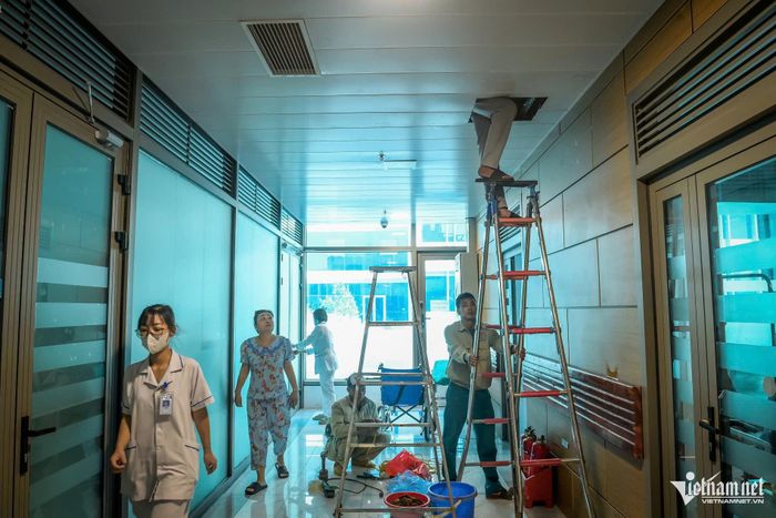 Tại sảnh tầng 3, tòa nhà E, Khoa Truyền nhiễm, công nhân đang vệ sinh tổng thể hệ thống điều hòa.