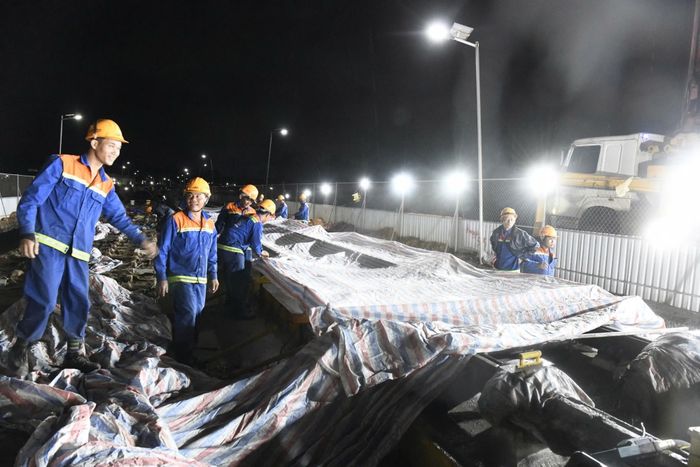 Phú Quốc đang vào mùa mưa, công nhân phải tranh thủ những lúc trời tạnh để thi công 3 ca, 4 kíp. Khi mưa, phải dựng bạt che để tiếp tục công việc. Ảnh: Khải Anh