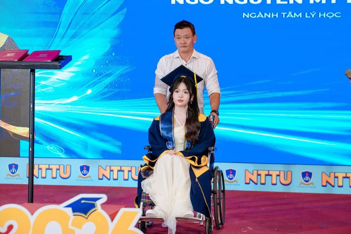 Hơn 20 năm làm đôi chân của con, lần này ông Ngô Văn Dũng đẩy xe lăn cùng con nhận bằng tốt nghiệp. Ảnh: TN