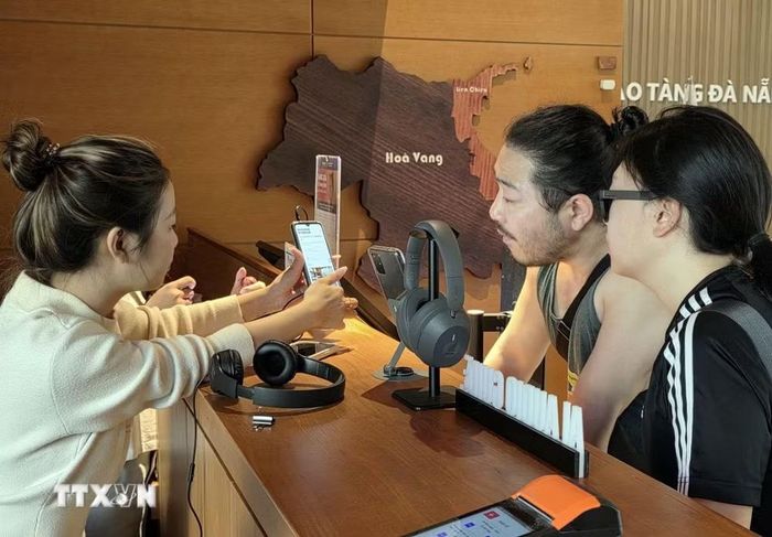Hướng dẫn du khách sử dụng công nghệ số để tìm hiểu các thông tin khi đi tham quan Bảo tàng Đà Nẵng. (Ảnh: Trần Lê Lâm/TTXVN)