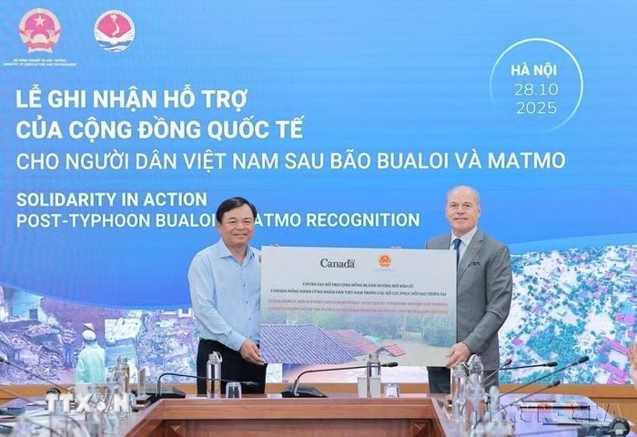 Ông Nguyễn Hoàng Hiệp, Thứ trưởng Bộ Nông nghiệp và Môi trường tiếp nhận hỗ trợ từ ông James Nickel, Đại sứ Canada tại Việt Nam tại Lễ ghi nhận của cộng đồng quốc tế cho người dân Việt Nam sau bão Bualoi và Matmo (Hà Nội, 28/10/2025). (Ảnh: Lê Đông/TTXVN)