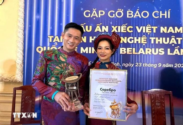 Hai nghệ sỹ Hiển Phước (trái) và Thanh Hoa (Trung tâm Nghệ thuật Thành phố Hồ Chí Minh) chia sẻ về Giải Bạc tại Liên hoan Nghệ thuật Xiếc Quốc tế Minsk (Belarus). (Ảnh: Hữu Duyên/TTXVN)