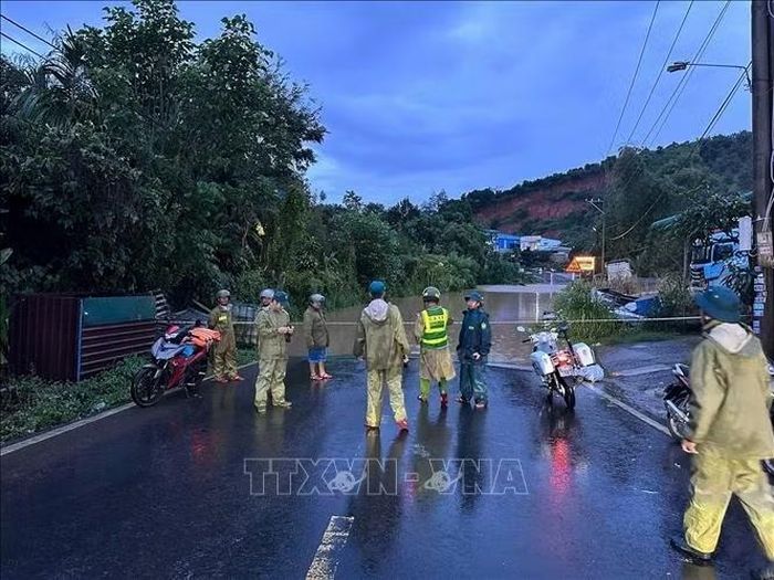 Lực lượng chức năng phân luồng giao thông tại khu vực cống ngầm bị ngập trên Quốc lộ 55, đoạn qua xã Bảo Lâm 3, tỉnh Lâm Đồng. Ảnh: TTXVN phát