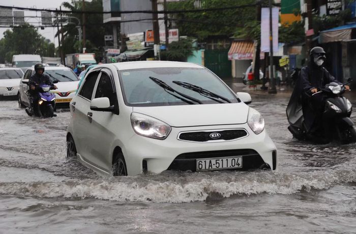 Các phương tiện lưu thông qua điểm ngập trên đường Đinh Bộ Lĩnh.
