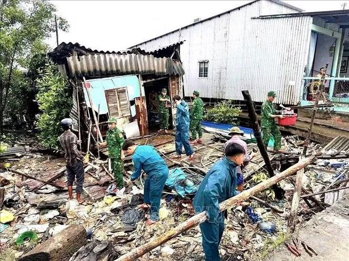 Các lực lượng phối hợp cùng người dân khắc phục phần nhà bị thiệt hại sau thiên tai. Ảnh: TTXVN phát.