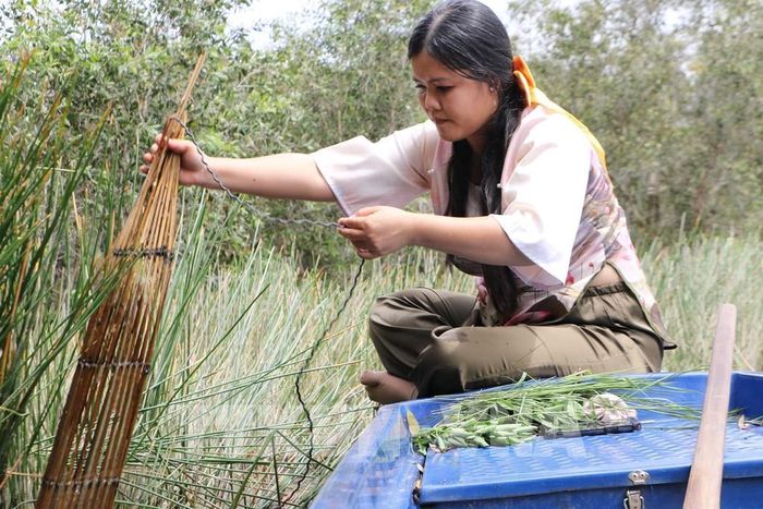 Du khách trải nghiệm đặt trúm lươn tại Khu du lịch Tràm Chim. Ảnh: Hồng Thái - TTXVN