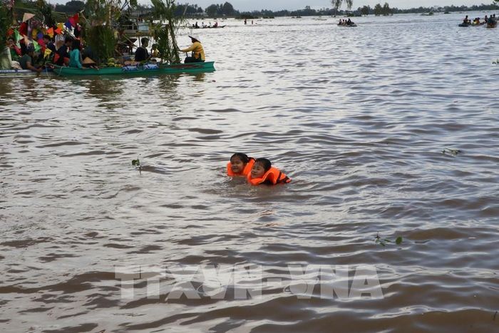 Trẻ em trải nghiệm tắm đồng mùa nước nổi tại phường Hồng Ngự (Đồng Tháp). Ảnh: Hồng Thái - TTXVN