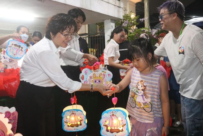 Bà Nguyễn Thị Tuyết Hạnh, Phó Chủ tịch Ủy ban MTTQ Việt Nam phường, Chủ tịch Hội LHPN phường Tân Tạo, TPHCM (bìa trái) trao lồng đèn cho các em nhỏ.