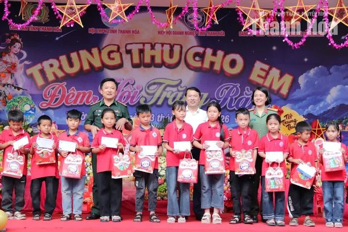 Đại diện Công an tỉnh, Ban Chỉ huy BĐBP tỉnh và lãnh đạo xã Trường Lâm trao quà cho các cháu mồ côi, học sinh có thành tích học tập tốt.