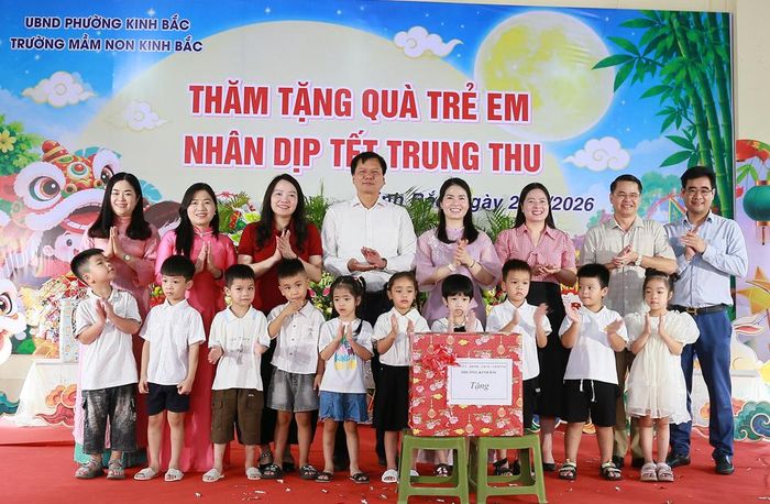  Đồng chí Tạ Đăng Đoan và các đại biểu trao quà của Đảng ủy - HĐND - UBND - Ủy ban MTTQ phường cho cô, trò Trường Mầm non Kinh Bắc. 